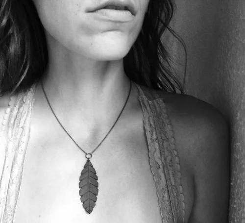 A feather-leaf leather pendant worn on a fine chain